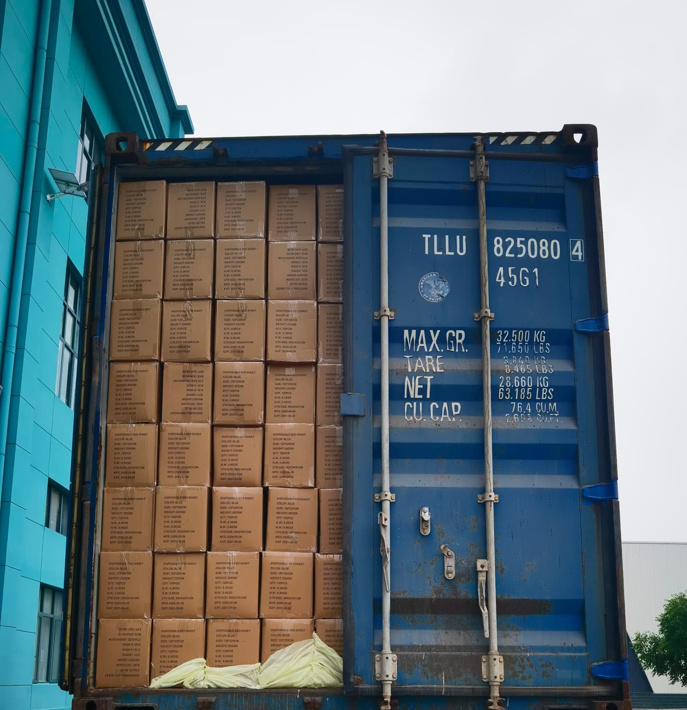 A blue container loaded with cartons of medical supplies, one door still open