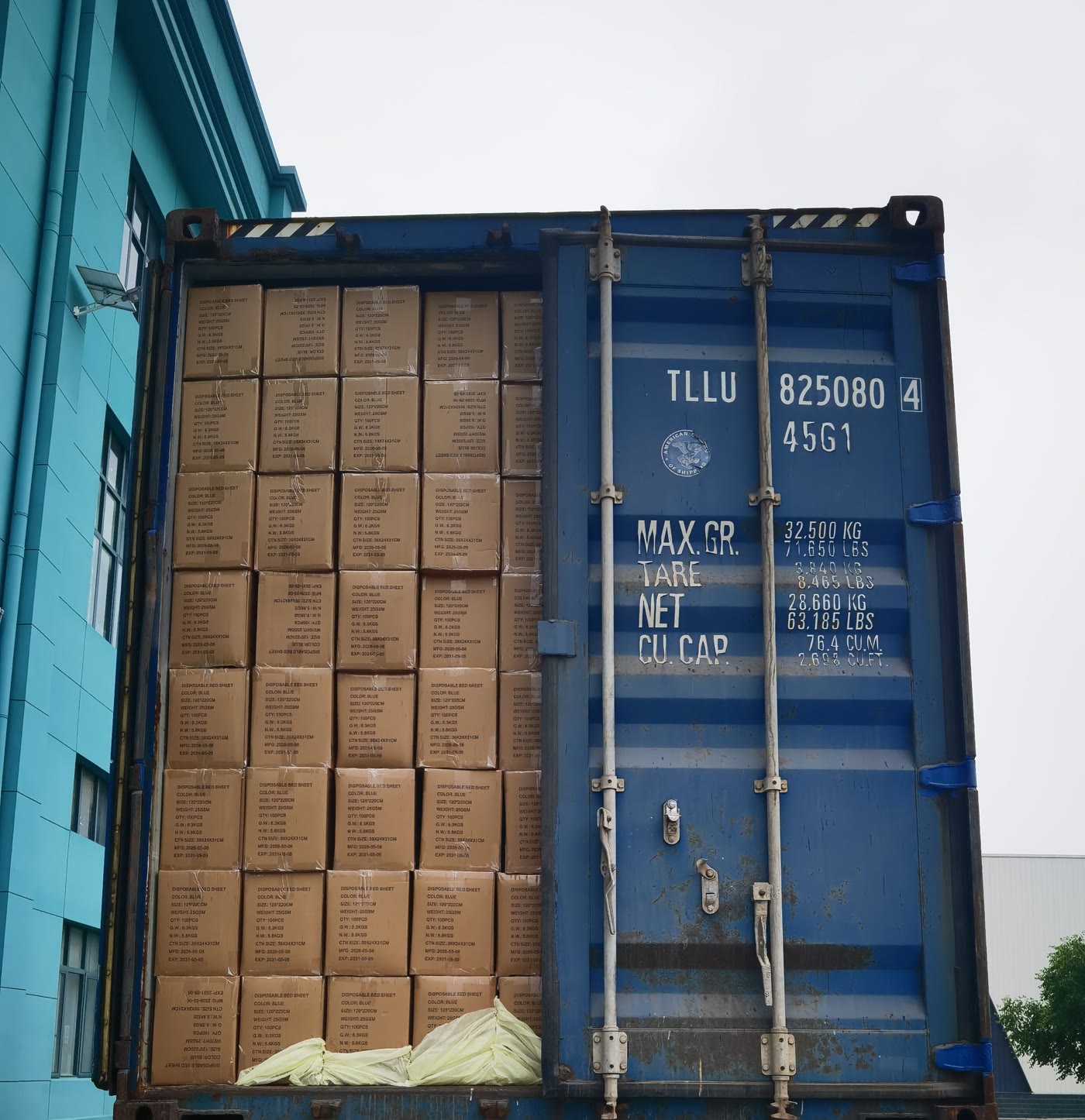 A blue container loaded with cartons of medical supplies, one door still open